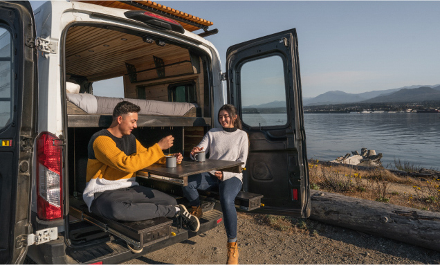 Two people having coffee in a campervan