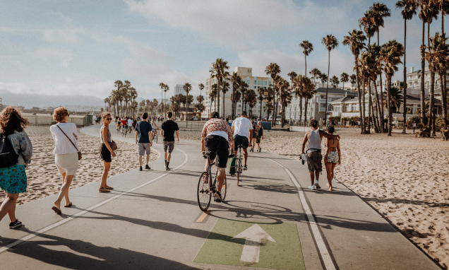People riding bikes along a beach boardwalk