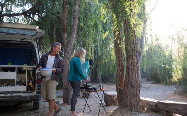 Two people in a campground making a meal