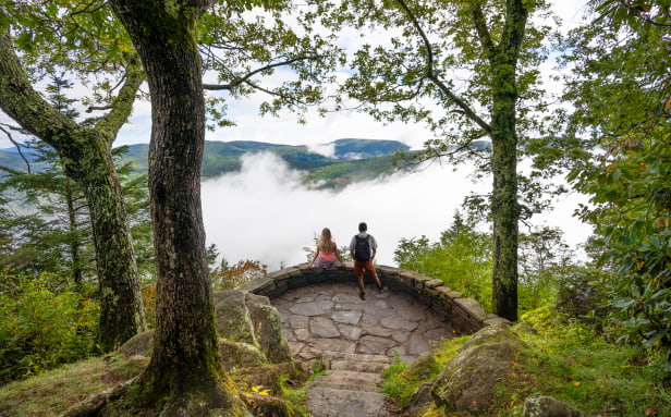A man and a woman hiking at an overlook